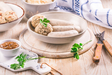White veal sausage (Weisswurst) with pickled white sour cabbage (Sauerkraut) and bread dumplings...