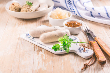White veal sausage (Weisswurst) with pickled white sour cabbage (Sauerkraut) and bread dumplings (Knodel)