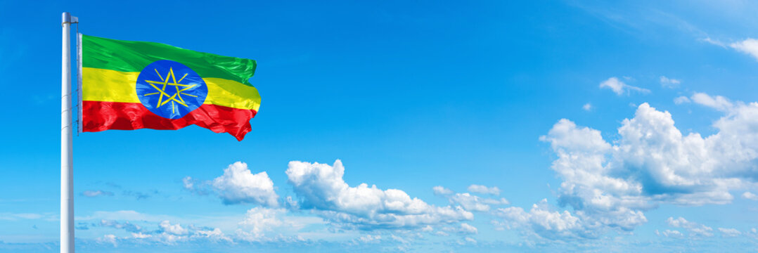 Ethiopia flag waving on a blue sky in beautiful clouds - Horizontal banner