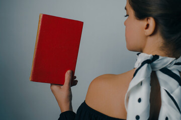 young woman with bare shoulders holding vintage books. High quality photo