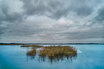 Obraz premium Storm clouds over frozen lake. Solitude on frozen lake.
