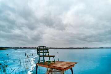 Naklejka na ściany i meble Storm clouds over frozen lake. Solitude on frozen lake.