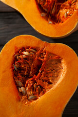 Fresh pumpkin cut into slices on the wooden table, close up view