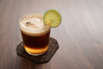 Espresso tonic in simple glass on walnut wood table with copy space