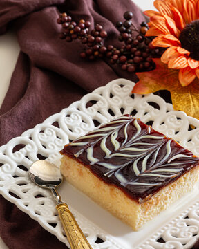 Trilece ( Tres leches ) cake made with fresh milk, condensed milk, heavy cream and caramel sauce served on the white  ceramic plate on the flower decorated table.