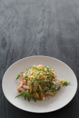 Fettuccine pasta with crab and arugula on black wood table