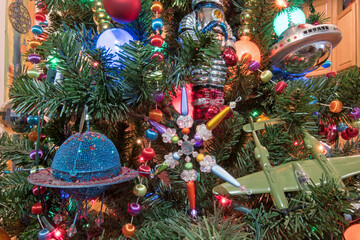 A Christmas tree is decorated in an air and space theme.