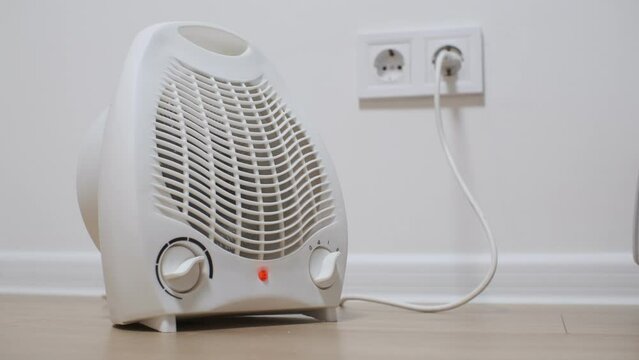 Close-up of an electronic fan heater set to maximum and heating the room due to a problem with the central heating.