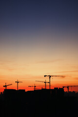 Fototapeta na wymiar Silhouette of construction cranes at sunset.