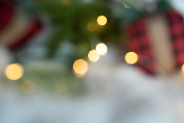 Christmas tree branch and a gift in a red package. Photo out of focus. People with poor eyesight, farsightedness. Postcard for Christmas and New Year. christmas background