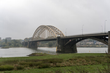 Historic bridge named "Waalbrug" over the river Waal  by Nijmegen, The Netherlands on a morning with overcast sky