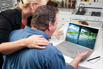 Couple In Kitchen Looking at a Vacation Rental on Their Laptop 