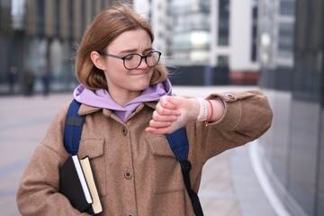 Stressed anxious young girl, woman is late busy university or college student with books, textbooks...