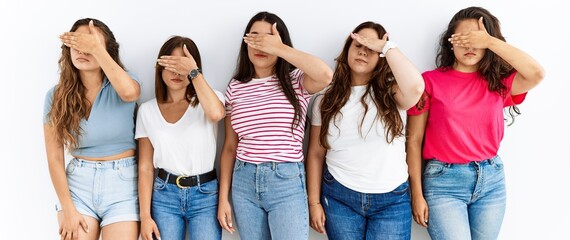 Group of women wearing casual clothes standing over isolated background covering eyes with hand,...