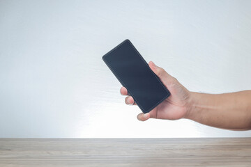 A cropped hand holding a smartphone isolated on white background