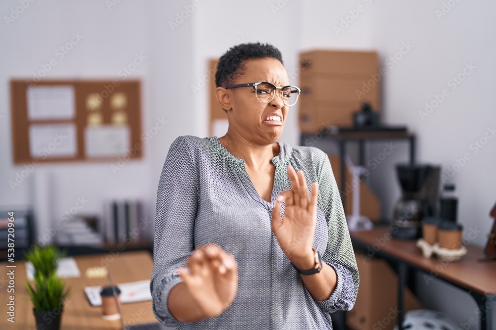 Canvas Prints African american woman working at the office wearing glasses disgusted expression, displeased and fearful doing disgust face because aversion reaction. with hands raised