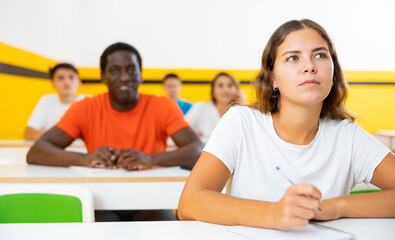 Multiethnic group of people studying together at table. Focus on euroepan woman