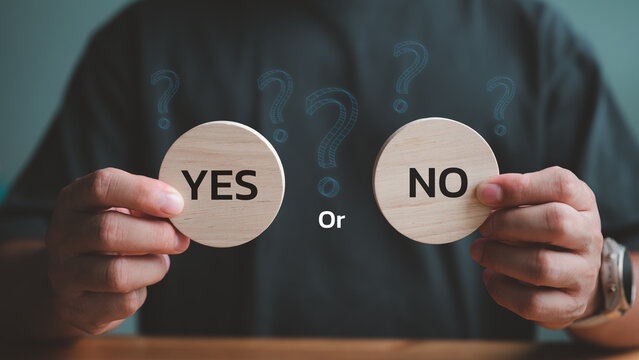 Think With Yes Or No Choice, Business Choices For Difficult Situations, Yes or no and question mark, man holding two wooden with yes or no word on it, making decision.. - Powered by Adobe