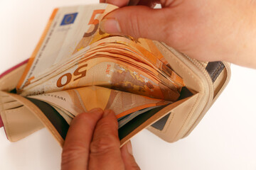 woman taking euro banknotes out of her wallet