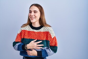 Young hispanic girl standing over blue background smiling and laughing hard out loud because funny...