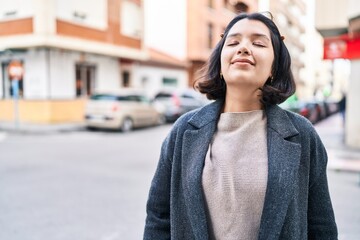 Young woman smiling confident breathing at street