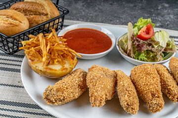 Delicious crispy fried chicken breast strips served with potatoes and salads,Chicken nuggets,