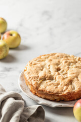 Apple pie Charlotte with apples on white marble background. Text space