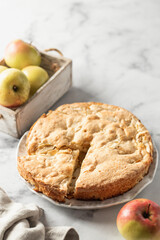 Apple pie Charlotte with apples on white marble background. Text space