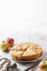 Apple pie Charlotte with apples on white marble background. Text space