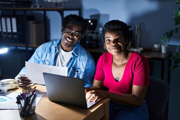 African american man and woman business workers using laptop working at office