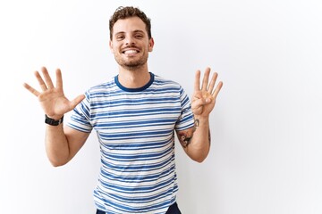 Fototapeta premium Handsome young man standing over isolated background showing and pointing up with fingers number nine while smiling confident and happy.