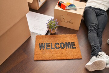Young hispanic man lying on floor at new home