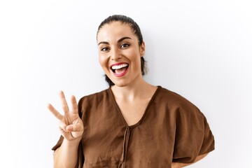 Obraz na płótnie Canvas Young brunette woman standing over isolated background showing and pointing up with fingers number three while smiling confident and happy.