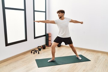 Young arab man smiling confident training yoga at sport center