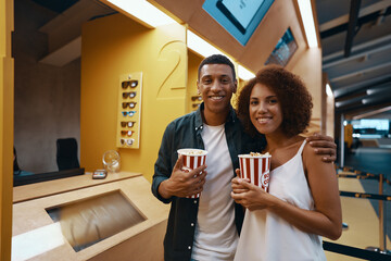People came to the premiere of the film with popcorn. Happy couple at the cinema.
