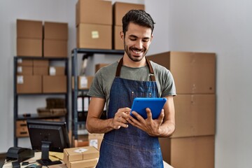 Young hispanic man business worker using touchpad at storehouse
