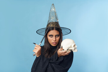 Young witch casting a spell with a skull and a wand