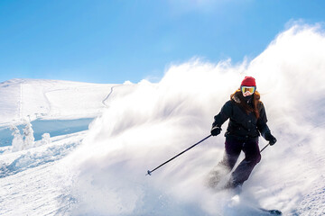 Fototapeta na wymiar Women in winter overalls skiing on fresh powder snow hill at mountains at winter alpine ski resort