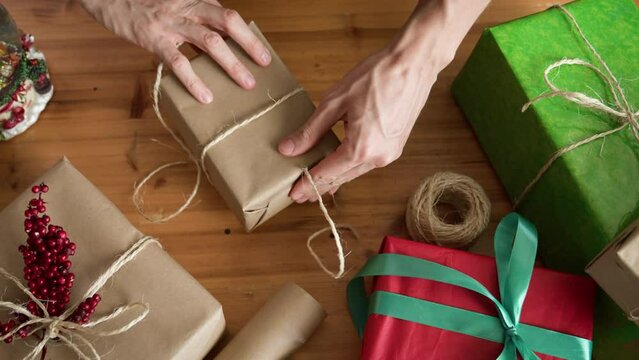 Man wrapping Christmas gift with twine. Christmas or New year DIY packing Concept. 