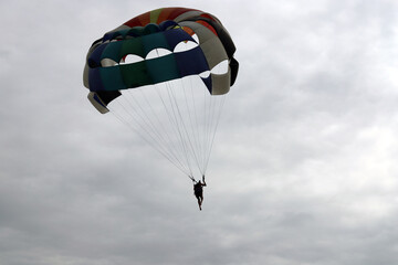 Skydiver enjoys a cloudy sky over the ocean	