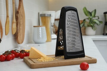 Grater, cheese and cherry tomatoes on kitchen counter