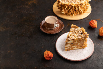 Traditional lithuanian cake shakotis with cup of coffee on black, side view, copy space.
