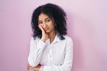 Hispanic woman with curly hair standing over pink background thinking looking tired and bored with...