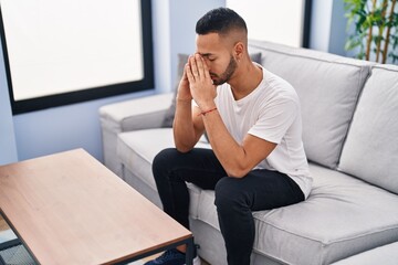 African american man stressed sitting on sofa at home