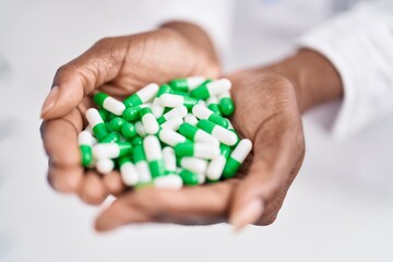 African american woman pharmacist holding pills at pharmacy