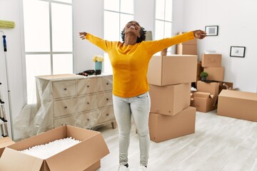 African american woman smiling confident standing with arms open at new home
