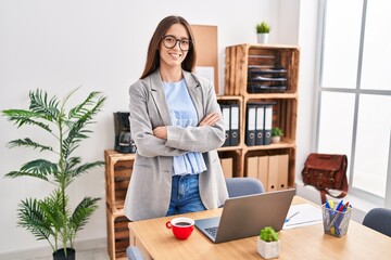 Young beautiful hispanic woman business worker smiling confident standing with arms crossed gesture at office