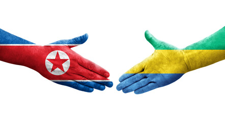 Handshake between Gabon and North Korea flags painted on hands, isolated transparent image.