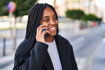 African american woman smiling confident talking on the smartphone at street