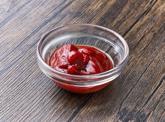  Bowl of tomato sauce on wooden surface